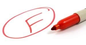 F written on a page in red with a marker sitting nearby